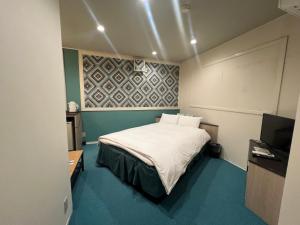 En eller flere senge i et værelse på Hotel Firstwood 大栄店