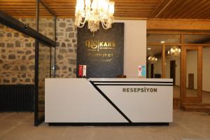 a reception desk in a room with a chandelier at Ve Hotels Beylerbeyi Sarayı in Kars
