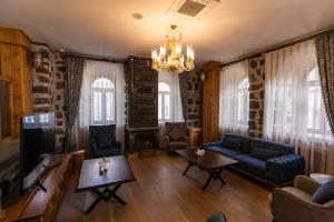 a living room with a couch and a tv at Ve Hotels Beylerbeyi Sarayı in Kars