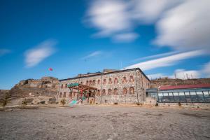 卡爾斯的住宿－Ve Hotels Beylerbeyi Sarayı，一座蓝色天空的大石头建筑