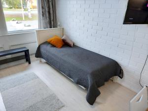 a bed in a room with a brick wall at Tuurin Yösäilö in Tuuri