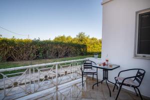 un patio con 2 sedie e un tavolo sul balcone di Stefano's Home a Potokáki