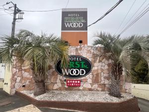Un cartel del hotel roza la madera con palmeras. en Hotel Firstwood 大栄店, en Narita 25 fotos más