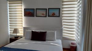 Beach Paradise Nilaveli في ترينكومالي: غرفة نوم بسرير بأربع صور على الحائط