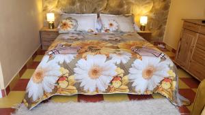 una camera da letto con un letto fiorito di Liget Nyaralóház és Apartman Liget a Szilvásvárad