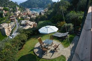 un tavolo e sedie con ombrellone su un balcone di B&B Portofino a Portofino