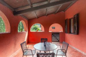 スポレートにあるAgriturismo Collelignaniのオレンジ色の壁の客室で、テーブルと椅子が備わります。