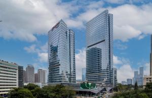 zwei hohe Wolkenkratzer in einer großen Stadt in der Unterkunft Hampton by Hilton Shenzhen Nanshan Science and Technology Park in Shenzhen