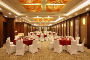 a banquet hall with tables and white chairs at Crowne Plaza New Delhi Okhla, an IHG Hotel in New Delhi