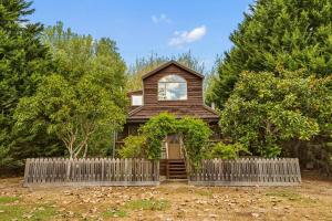 een houten huis met een hek ervoor bij StayAU The Loft 1BR Rustic Picturesque Cottage in Badger Creek