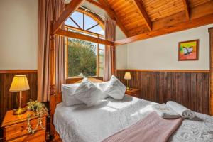 een slaapkamer met een groot bed en een raam bij StayAU The Loft 1BR Rustic Picturesque Cottage in Badger Creek