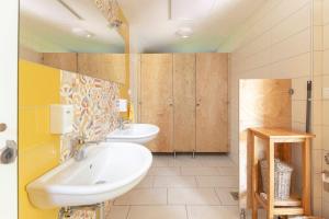 a bathroom with two sinks and wooden cabinets at Glamping Mohorjev grunt in Preddvor