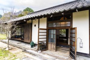 una pequeña casa con puertas de madera y una boca de incendios en しまなみ宿Gyoku, en Imabari