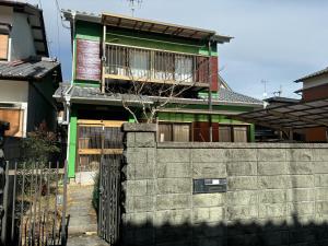 a house with a fence in front of it at 高知県　みどりの家 in Gomen