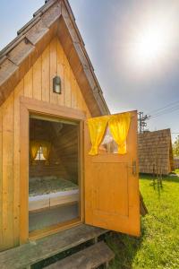 a small wooden house with a door and a window at Glamping Mohorjev grunt in Preddvor