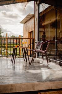 einen Tisch und zwei Stühle auf einer Terrasse in der Unterkunft Nila Chandra Bungalows in Ubud