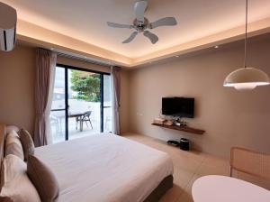 a bedroom with a bed and a ceiling fan at Qixingtan Xinghai B&B in Dahan