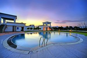 a large swimming pool in front of a house at Royal Sarovar Portico Siliguri in Siliguri