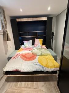 塞特港的住宿－CARPE DIEM，一间卧室配有一张带色彩缤纷的毯子和枕头的床。