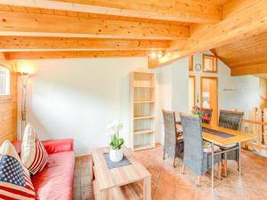 sala de estar con sofá rojo y mesa de madera en Urbane Apartment in Sankt Gallenkirch with Balcony, en Sankt Gallenkirch