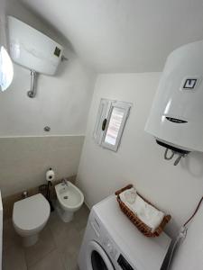 a bathroom with a washing machine and a toilet at Aura Entis in Canino +6 photos