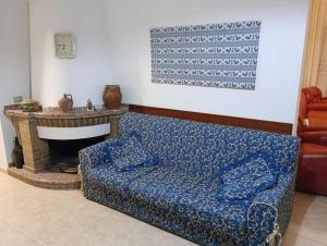 sala de estar con sofá azul y chimenea en CASA FIGUS Via Roma 20 Narbolia, en Narbolia
