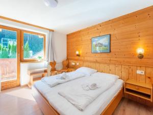 1 dormitorio con 1 cama blanca grande y paredes de madera en Pretty Apartment in Oberau with Infrared Sauna, en Oberau