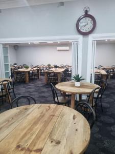 une chambre avec des tables et des chaises et une horloge sur le mur dans l'établissement Commercial Hotel Young, à Young