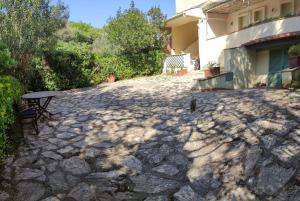 a stone patio with a table in front of a house at Bilocale a due passi dal mare immerso nel verde in Castiglioncello