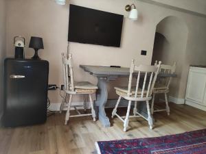 a room with a table with chairs and a television on the wall at Bilocale a due passi dal mare immerso nel verde in Castiglioncello