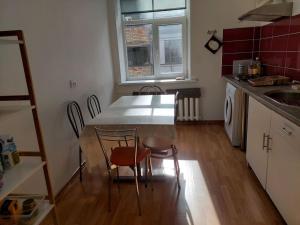 a kitchen with a table and chairs and a sink at Bright spacious apartment with street parking in Rīga