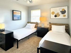 a bedroom with two beds and a desk with lamps at Stunning 3br Oasis Rainshower Family Fun in Oklahoma City