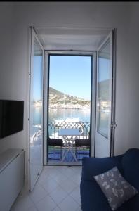 een woonkamer met een glazen schuifdeur naar een balkon bij Rd Guest house in Ischia