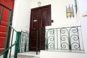 a wooden door on a white building with a railing at Rd Guest house in Ischia