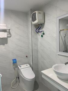 Baño blanco con aseo y lavamanos en Đông Đô Hotel en Hai Phong