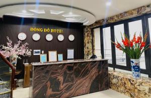 una hall con orologi appesi al muro e fiori di Đông Đô Hotel a Hai Phong