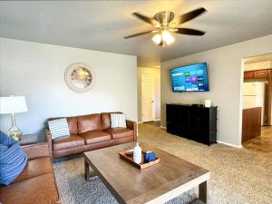 a living room with a couch and a flat screen tv at Stunning 3br Oasis Rainshower Family Fun in Oklahoma City