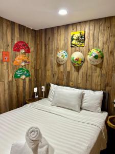 1 dormitorio con cama y pared de madera con sombrillas en Rom Casa Hostel Da Nang en Da Nang