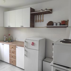 a kitchen with white cabinets and a white refrigerator at Vila Obradovic in Arilje