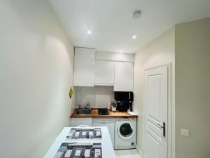 a small kitchen with a washing machine and a washer at Suffren Studio in Paris