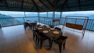 a dining room with tables and chairs on a balcony at Hilton Cloud Resort in Wayanad