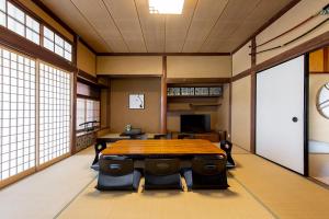 una grande camera con tavolo e sedie in legno di 【Oyado龍】檜の露天風呂付 和モダンな古民家115㎡貸し切りの宿 1日1組限定【8名宿泊可能】 a Asahimachi