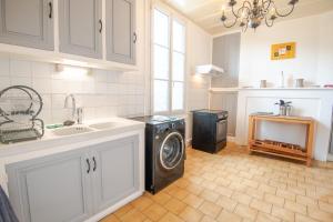 a kitchen with a washing machine and a sink at La Maison du Bonheur - Francueil in Francueil