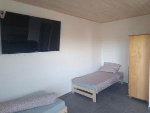 OkuniowiecにあるAgroturystyka Żuczekのベッド2台、薄型テレビが備わる客室です。
