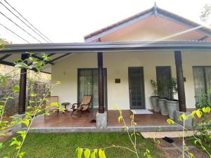 ein kleines Haus mit einer Terrasse in der Unterkunft Tamarind Tree Garden Resort - Katunayake in Negombo