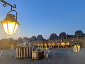 światło uliczne z budynkiem w tle w obiekcie Suites Mana - Bleu Pacifique - Vue sur Place Ducale avec Parking privé inclus w mieście Charleville-Mézières
