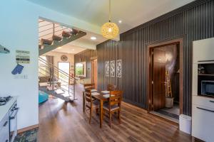 Keenoo Villa - An elegant villa in a calm area في بامبلِماوسز: مطبخ وغرفة طعام مع طاولة وكراسي