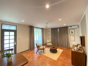 ein Wohnzimmer mit 2 Stühlen und einem Tisch in der Unterkunft Tamarind Tree Garden Resort - Katunayake in Negombo