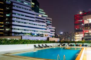 a swimming pool on the roof of a building at night at Bangkok Hotel Lotus Sukhumvit 33 by Compass Hospitality in Bangkok