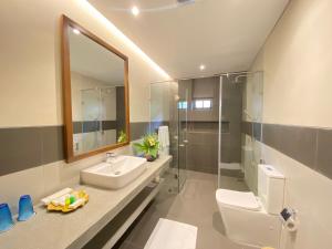 a bathroom with a toilet and a sink and a mirror at Tamarind Tree Garden Resort - Katunayake in Negombo